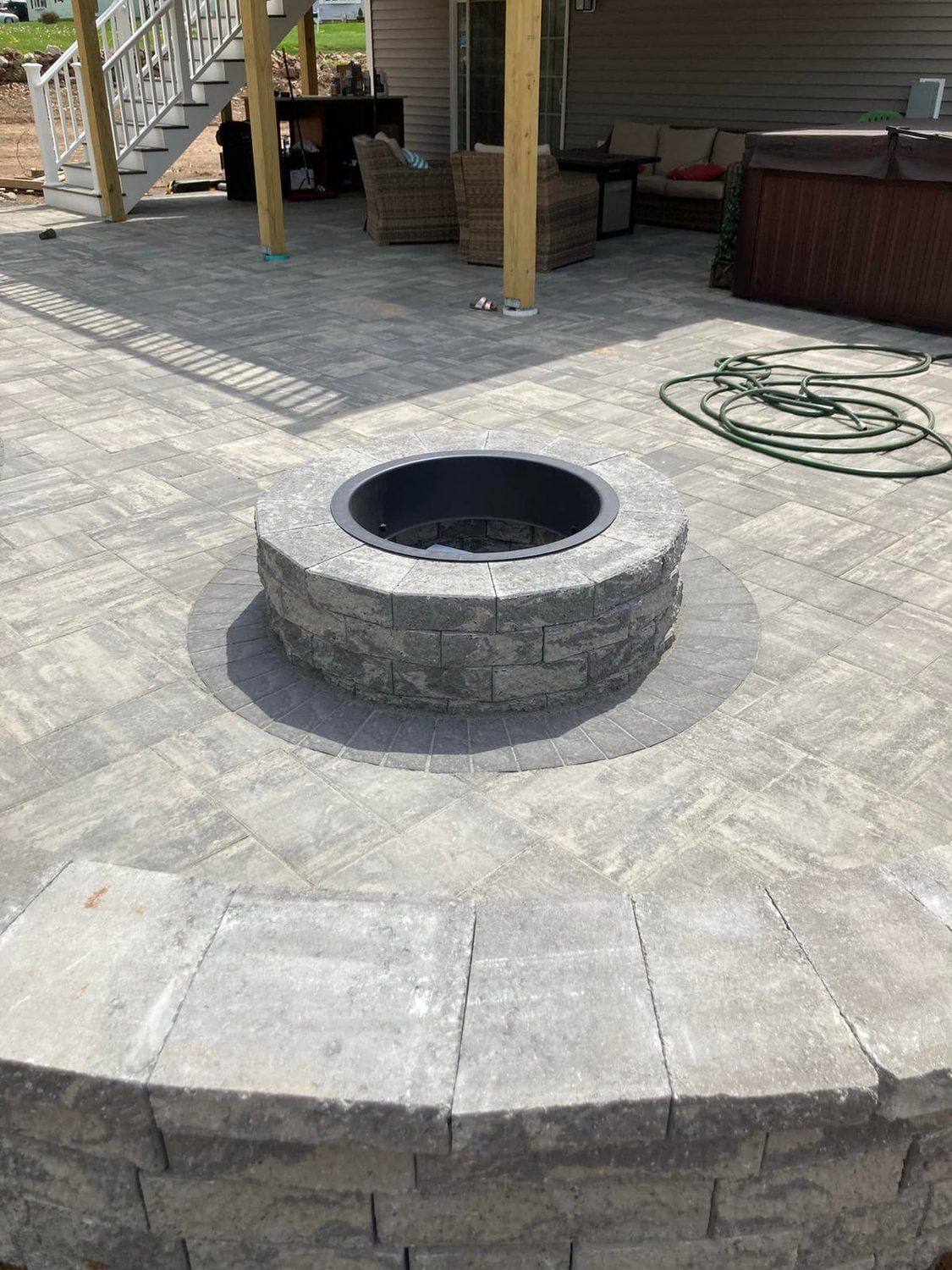 Round stone fire pit on a paver patio by TNT Masonry & Pavers in Connecticut